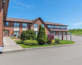 Hotel exterior with lounge seating and parking area at Comfort Inn Moncton Magnetic Hill.