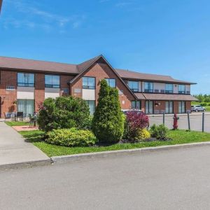 Hotel exterior with lounge seating and parking area at Comfort Inn Moncton Magnetic Hill.