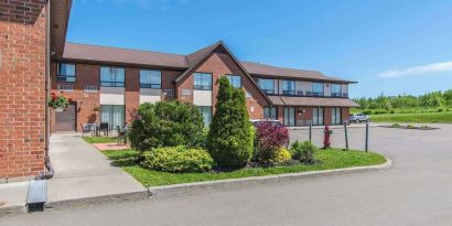 Hotel exterior with lounge seating and parking area at Comfort Inn Moncton Magnetic Hill.