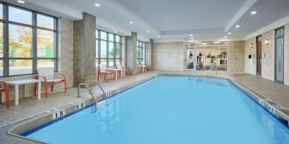 Indoor heated pool with lounge chairs at Holiday Inn & Suites Oakville At Bronte.