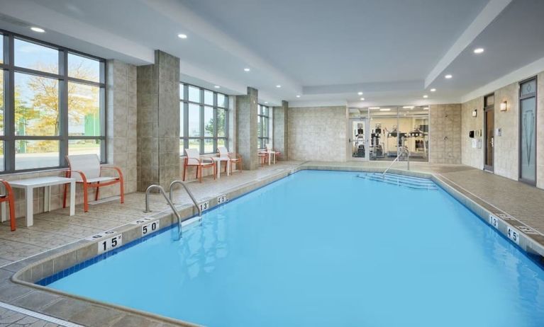 Indoor heated pool with lounge chairs at Holiday Inn & Suites Oakville At Bronte.