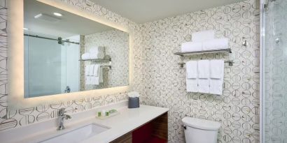 Guest bathroom with shower and free toiletries at Holiday Inn & Suites Oakville At Bronte.