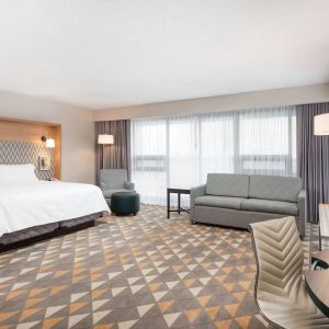 Bright and spacious king room with work desk and sofa at Holiday Inn Toronto Airport East.