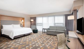 Bright and spacious king room with work desk and sofa at Holiday Inn Toronto Airport East.