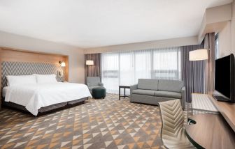 Bright and spacious king room with work desk and sofa at Holiday Inn Toronto Airport East.