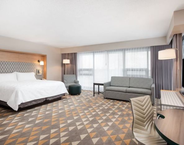 Bright and spacious king room with work desk and sofa at Holiday Inn Toronto Airport East.