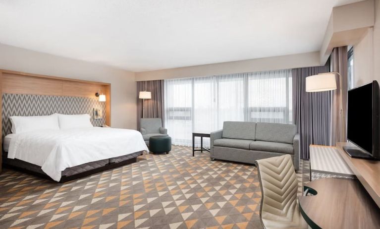 Bright and spacious king room with work desk and sofa at Holiday Inn Toronto Airport East.