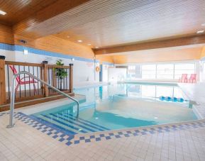 Relaxing indoor pool with lounge seating at Les Suites Hotel Ottawa.