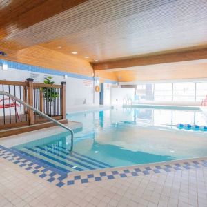 Relaxing indoor pool with lounge seating at Les Suites Hotel Ottawa.