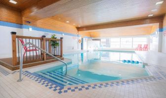 Relaxing indoor pool with lounge seating at Les Suites Hotel Ottawa.