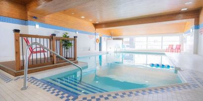 Relaxing indoor pool with lounge seating at Les Suites Hotel Ottawa.