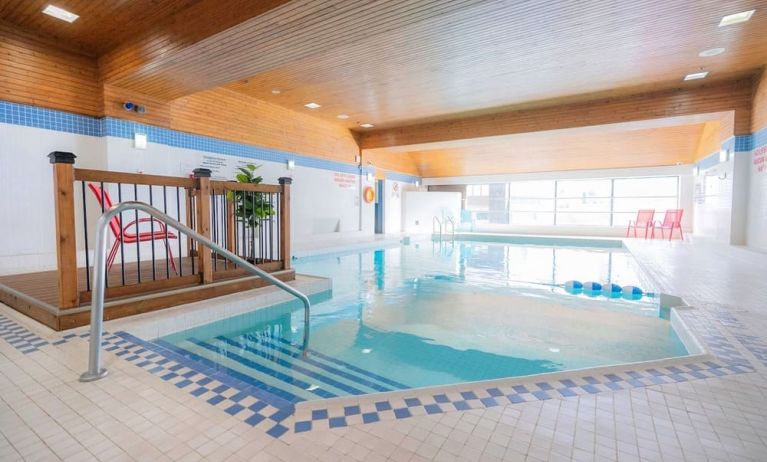 Relaxing indoor pool with lounge seating at Les Suites Hotel Ottawa.