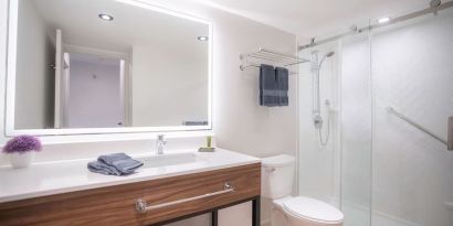 Guest bathroom with shower and free toiletries at Les Suites Hotel Ottawa.