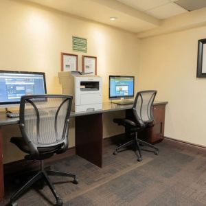 Business center with computers, printer and ergonomic chairs at Les Suites Hotel Ottawa.