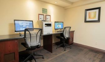 Business center with computers, printer and ergonomic chairs at Les Suites Hotel Ottawa.