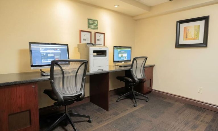 Business center with computers, printer and ergonomic chairs at Les Suites Hotel Ottawa.