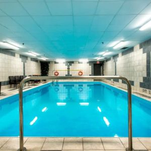 Indoor heated pool with lounge chairs at Halifax Airport Hotel.