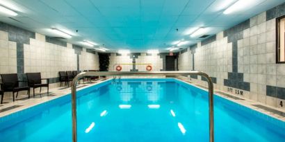 Indoor heated pool with lounge chairs at Halifax Airport Hotel.