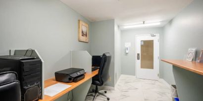 Business center with computers, printer and ergonomic chairs at Halifax Airport Hotel.