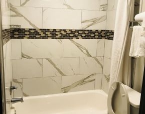 Guest bathroom with shower and tub at Summit Inn Near Houston Medical Center-NRG Park.