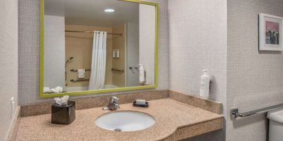 Guest bathroom with shower and tub at Hampton Inn & Suites Dallas/Allen.