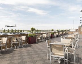 Hotel terrace with comfortable seating and airport view at Thistle London Heathrow Terminal 5.