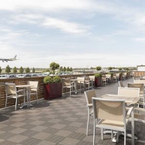 Hotel terrace with comfortable seating and airport view at Thistle London Heathrow Terminal 5.