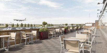 Hotel terrace with comfortable seating and airport view at Thistle London Heathrow Terminal 5.