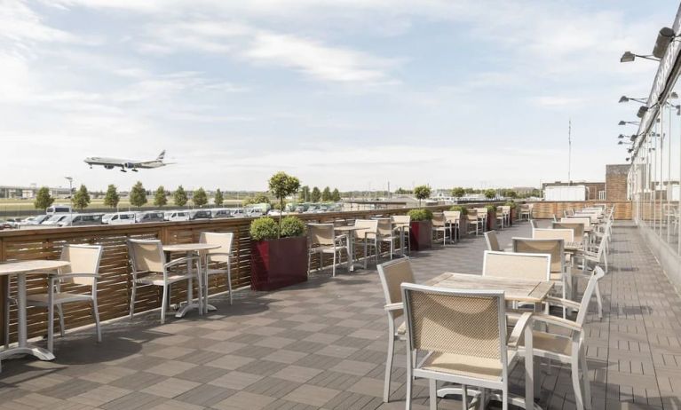 Hotel terrace with comfortable seating and airport view at Thistle London Heathrow Terminal 5.