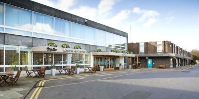 Hotel entrance with outdoor sitting area at Thistle London Heathrow Terminal 5.