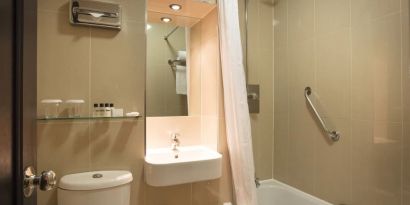 Guest bathroom with tub and free toiletries at Thistle London Heathrow Terminal 5.