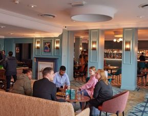 Dining area with comfortable seating and billiards at Thistle London Heathrow Terminal 5.