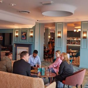 Dining area with comfortable seating and billiards at Thistle London Heathrow Terminal 5.