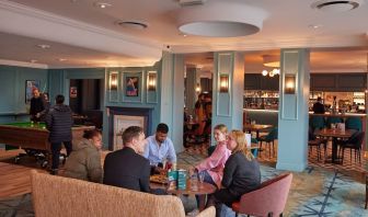 Dining area with comfortable seating and billiards at Thistle London Heathrow Terminal 5.