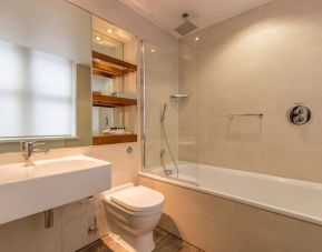 Guest bathroom with tub and free toiletries at Thistle Holborn, The Kingsley Hotel.