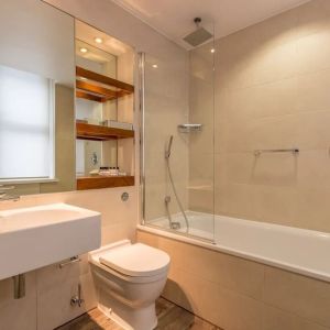 Guest bathroom with tub and free toiletries at Thistle Holborn, The Kingsley Hotel.