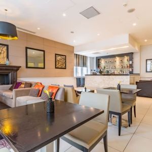 Hotel bar with comfortable seating and fireplace at Thistle Holborn, The Kingsley Hotel.