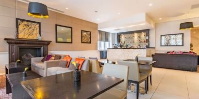 Hotel bar with comfortable seating and fireplace at Thistle Holborn, The Kingsley Hotel.