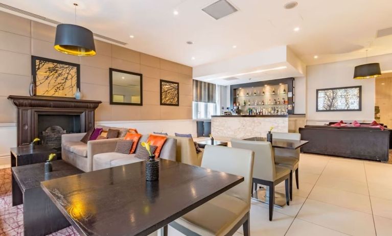 Hotel bar with comfortable seating and fireplace at Thistle Holborn, The Kingsley Hotel.