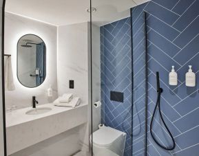 Guest bathroom with shower and free toiletries at Thistle Bloomsbury Park.