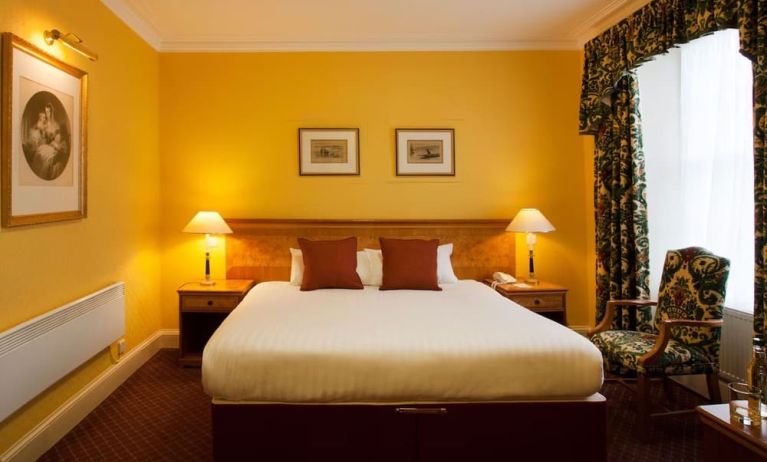 Single bed guest room in The Royal Highland Hotel, with bedside lamp and art on the wall.