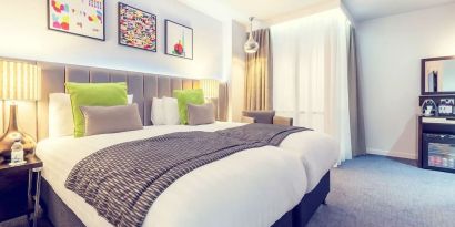 Bright and spacious day use twin room with work desk, sofa, mini bar and coffee maker at Mercure Hotel London Paddington.