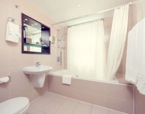 Guest bathroom with tub at Mercure Hotel London Paddington.