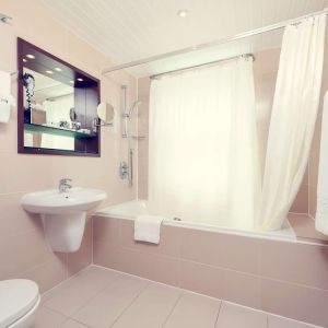 Guest bathroom with tub at Mercure Hotel London Paddington.