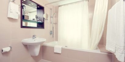 Guest bathroom with tub at Mercure Hotel London Paddington.