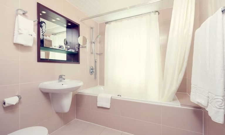 Guest bathroom with tub at Mercure Hotel London Paddington.