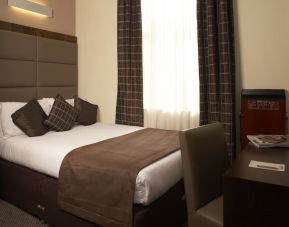 Queen bed and work desk at Mercure Hotel London Paddington.