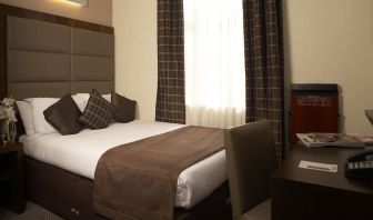 Queen bed and work desk at Mercure Hotel London Paddington.