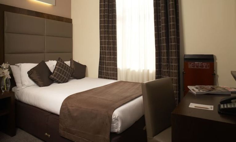 Queen bed and work desk at Mercure Hotel London Paddington.