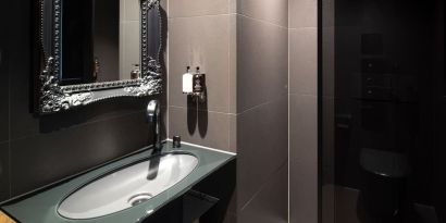 Guest bathroom with shower and free toiletries at Bloc Hotel.